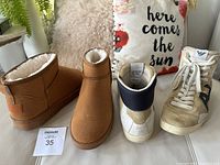 Pair of beige ankle booties with fleece lining and the AJ hightop runners side by side on a white surface with a floral pillow in background.