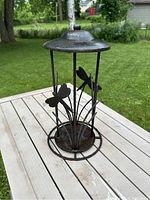 Photo of the whole metal candle holder showing dragonfly decorations and the lid on top