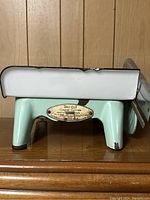 Side view of Tru-Cut cheese cutter showing metal legs and brass nameplate