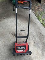 Front view of the red Murray TurboThrower 1500 electric snow blower with handle and power cord visible