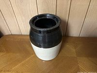 Front angled view of the ceramic jar showing two-tone black and white finish.