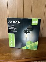 Photo showing the original box of NOMA Rockwell Outdoor Down Light with product image and specifications.