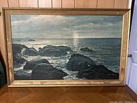 Full frontal view of the framed ocean rock painting showing the composition and colors.