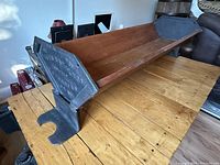 Long shot of the wooden trough showing the full length, wooden base with cast-iron metal ends.