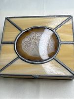 Top view of square stained glass jewelry box with yellow-beige panels and oval geode centerpiece on lid.