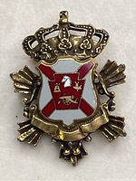 Front view of vintage enamel coat of arms pendant on copper tone metal showing detailed crown and shield with white, red and gold enamel.