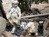 Overview of all garden decor statues including the 31-inch girl statue, two crowned monkeys, dog head, goose, Buddha head, and small bird figurines