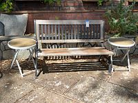 Front view of the outdoor garden bench with two round side tables positioned on each side. Bench is made of vertical and horizontal wood slats with a metal frame. Side tables have wood tops and metal folding legs.