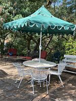 Full set including round table with umbrella and four matching chairs on a patio outdoors.