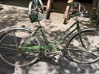 Full side view of green Schwinn Breeze women’s bicycle showing frame, wheels, saddle, and chain guard.