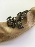 Front view of the antique Art Deco bow brooch displaying marcasite stone detailing on sterling silver.