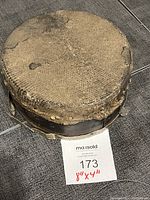 Top view of antique Mongolian drum showing worn textured drumhead with visible aging and use.