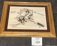 Full view of framed marble etching artwork showing Alaska map, bear, fisher, fish, in wood frame with maroon backing