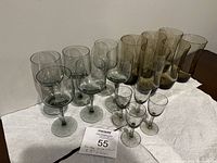 Front view showing all smoky glassware items arranged on a white surface against a plain background.