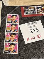 Four Elvis Presley 29-cent USA stamps featuring Elvis with a guitar on a pink background.