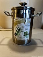 Front view of the stainless steel asparagus steamer showing the label and handles