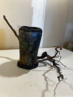 Front and side view of the handmade iridescent vase with branch extensions and textured rim and base.