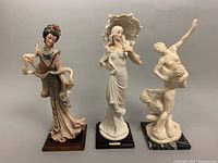 Three vintage Italian figurines lined up: a woman with scarf, a woman with hat, and classical dancers.