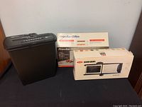 Photo of the Amazon Basics shredder, Proctor & Silex toaster box, and OXO Good Grips mandolin slicer box displayed together.