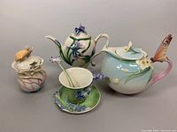 Overview of both teapots, cup, saucer, sugar jar and spoons