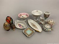 Overall assortment of vintage hand-painted porcelain chinaware, including decorative eggs, pedestal candy dish, serving pieces, sugar bowl and creamer set, and small dishes.