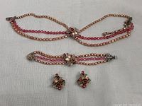 Full set including necklace, bracelet, and earrings laid out on white textured fabric.