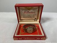 Wittnauer watch in original red presentation box with gold details and logo inside lid.
