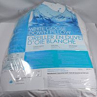 Front view of the packaged white goose down pillow showing product name and branding information.