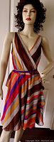 Full view of the wrap dress on a mannequin showing the multicolor diagonal stripes and neckline.