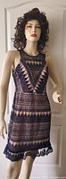Photo of mannequin wearing sleeveless navy blue crochet lace dress with nude lining showing intricate patterns and small ruffled hem