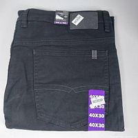 Folded black denim jeans with back pocket visible and size tags attached showing 40 X 30.