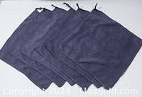 Six dark microfiber facial cloths stacked and fanned out, showing soft texture and loops for hanging.