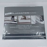 Packaged GlucksteinHome 4-piece double sheet set with brand name, product details, and images of the bedding in white color.