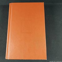 Front cover of the hardcover book showing plain orange/brown cover with embossed title barely visible.