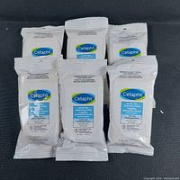 Photo showing 6 unopened packs of Cetaphil Gentle Skin Cleansing Cloths arranged on a cloth surface.