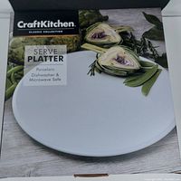 Photo showing front of box with product name, brand, and visuals of the porcelain serve platter.