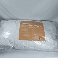 Full view of the pillow inside packaging showing brand, product type, and features.