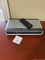 Bose 3500 stereo system main unit with remote control on top, showing front control panel