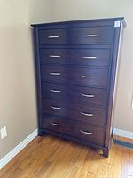 Front view of one high boy dresser showing all seven drawers and silver-tone handles