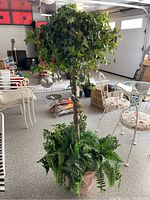 Full view of the artificial tree with ivy vine canopy and fern base in planter, showing height and surroundings