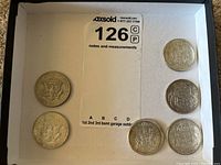 Six fifty cent coins displayed in a tray, showing both Canadian and American designs.
