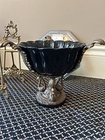Black fluted centerpiece bowl on brass stand with dolphin motifs