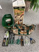 Full lot including Melnor deck sprayer with box, Turf Builder spreader, tool bag, moisture meter in package, assorted scissors and pruners.