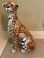Full front view of seated ceramic leopard