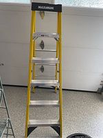 Full view of the Maximum fiberglass ladder showing yellow rails and aluminum steps.