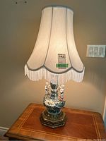 Lit lamp on table with shade visible