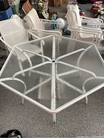 Overhead view of hexagonal glass top table showing frame and chairs in background