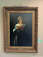 Full front view of reproduction painting in gilded frame with attached light