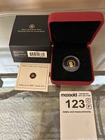 Overall view of coin in capsule, red presentation case, outer box and pamphlet