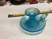 Blue antique glass finger candle holder with tape measure showing size, detailed view of design and handle